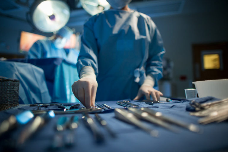 A surgeon performing surgery on a surgical table.