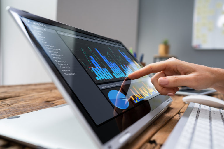 A Doctor working on a laptop with a graph displayed on the screen.